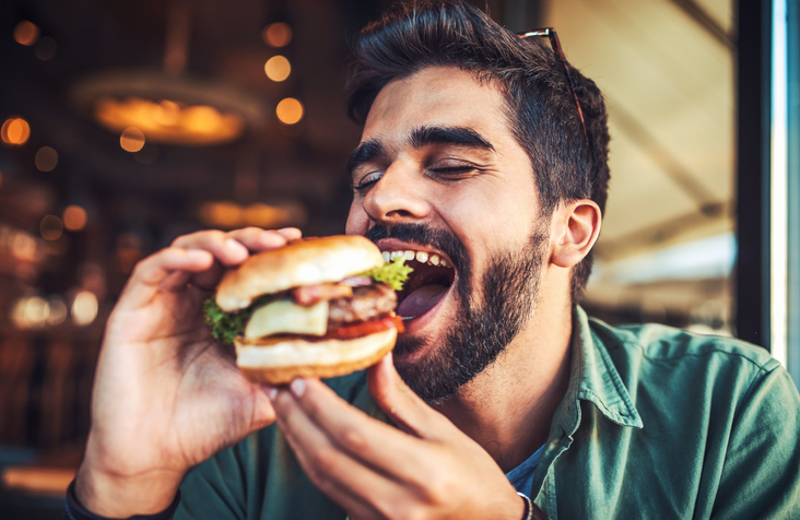 Mann som spiser en hamburger