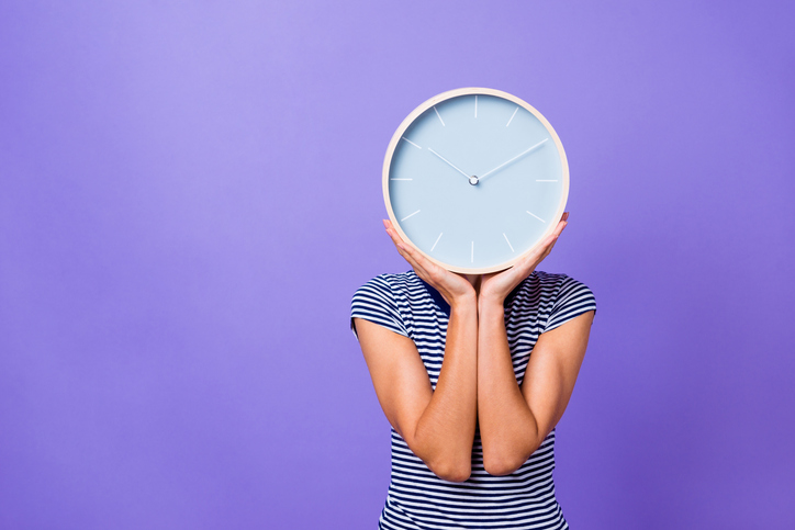 Kvinne med klokke foran hodet (istock)