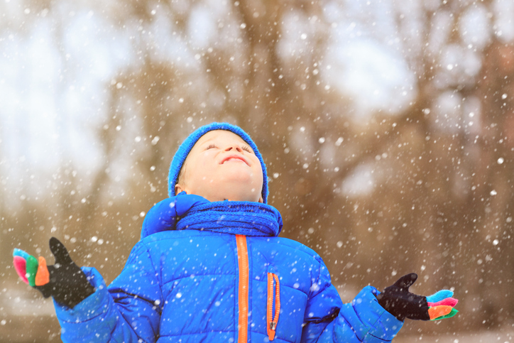 Gutt som holder hendene opp mot snøen (istock)